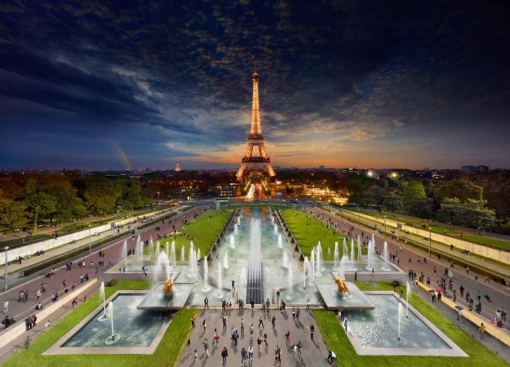 De Eiffeltoren torent uit boven de nachtelijke skyline en boven de veelkleurige ochtend.