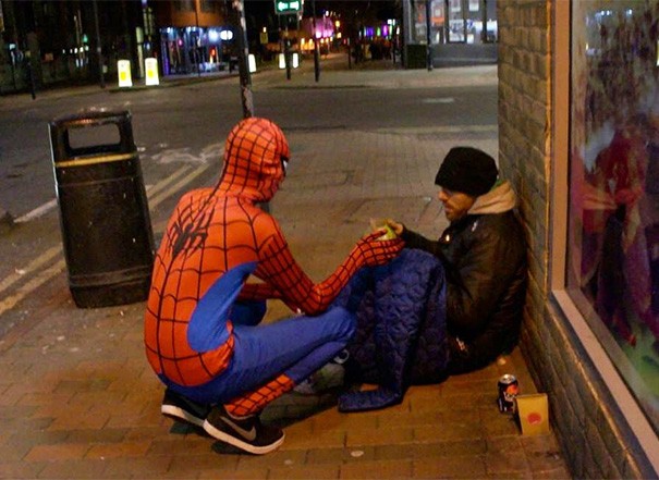 11. Uno sconosciuto vestito da Spiderman dà da mangiare ad un senzatetto