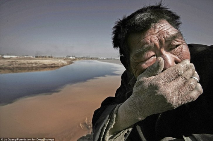 Un pastore si ripara dal fetido odore che proviene dal Fiume Giallo, Mongolia.
