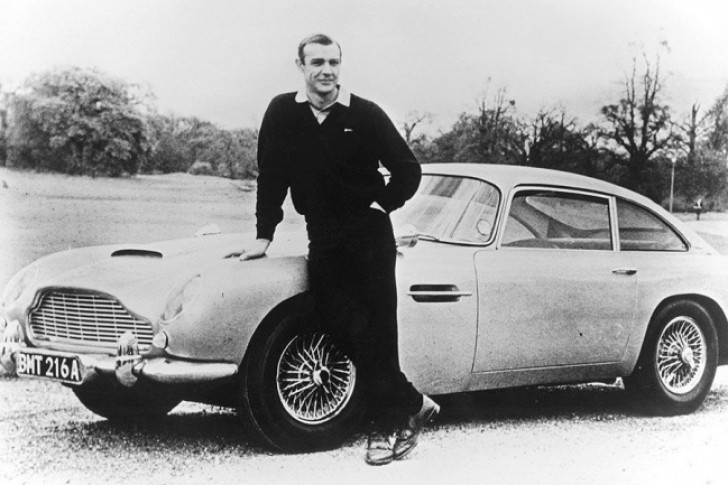 Sean Connery nei panni di James Bond davanti ad una Aston Martin DB5 - 1965