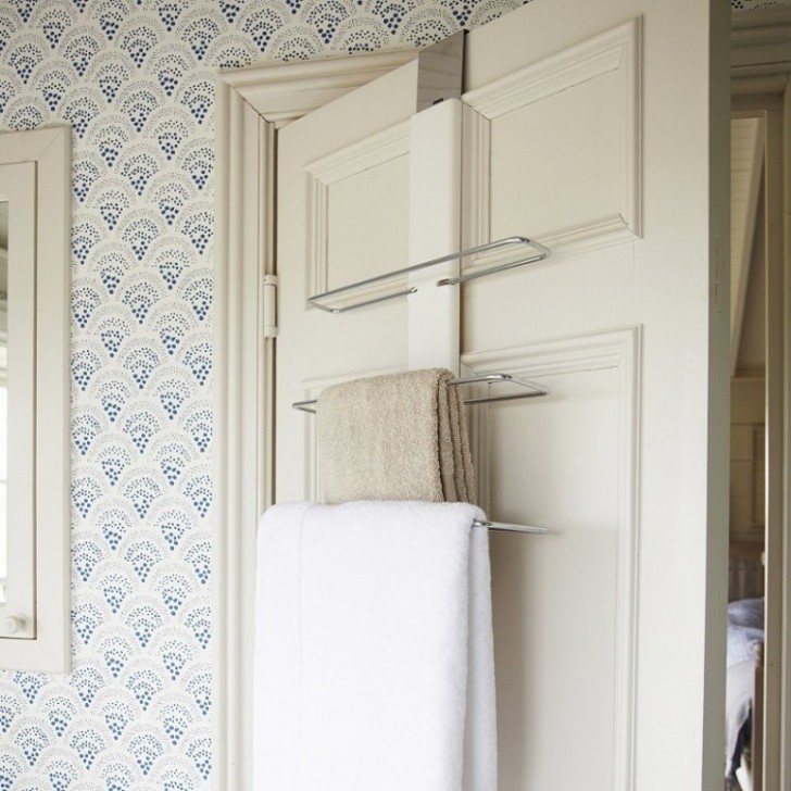 In un piccolo bagno, gli asciugamani possono essere sistemati dietro le porte.