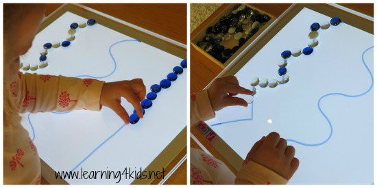 Potete disegnare sul tavolo stesso con pennarelli ad acqua, che si eliminano con solventi, e far sovrapporre ai bambini gemme colorate alle linee. Migliorerà la loro coordinazione.