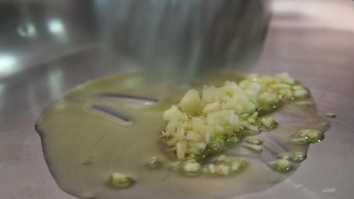 Soffriggere l'aglio in una padella dai bordi alti, con un filo d'olio, fono a doratura.