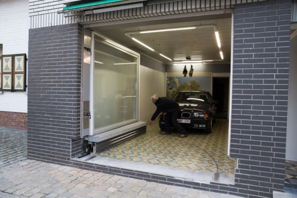 The large storefront window now has side hinges, so that it has been virtually transformed into a glass door. The wall portion of the storefront window garage door instead moves on wheels.