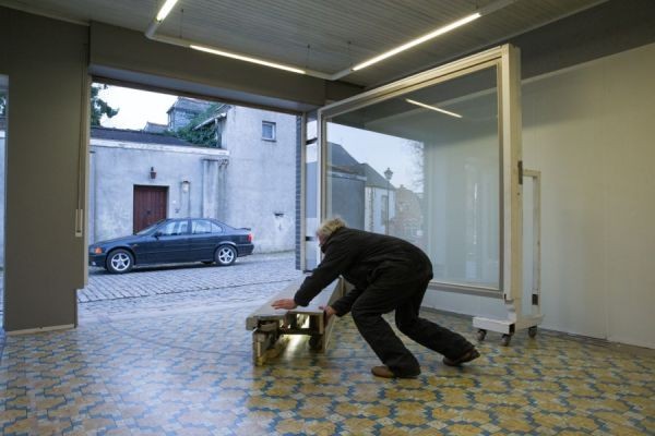 Als de auto uit de garage is, moet hij de garage nog afsluiten.