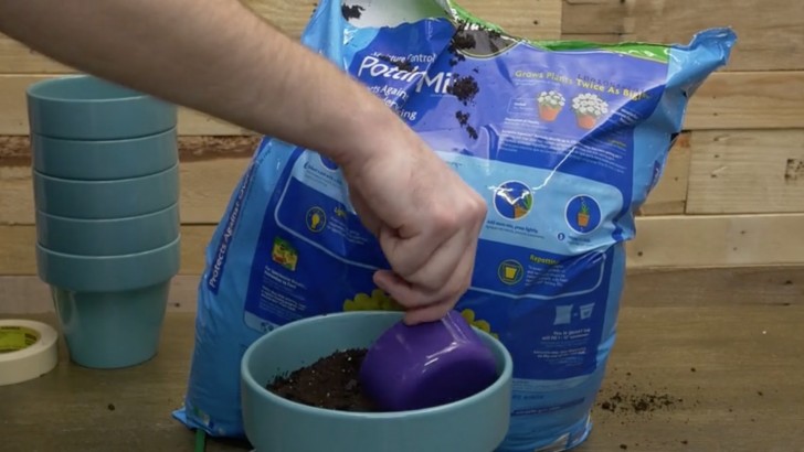 1. Riempite il vaso grande con uno strato di sassi e una buona quantità di terra (dovrà essere molto pesante!)