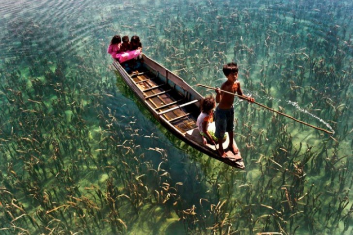Un bambino guida la barca sulle acque cristalline di Sabah, in Malesia.