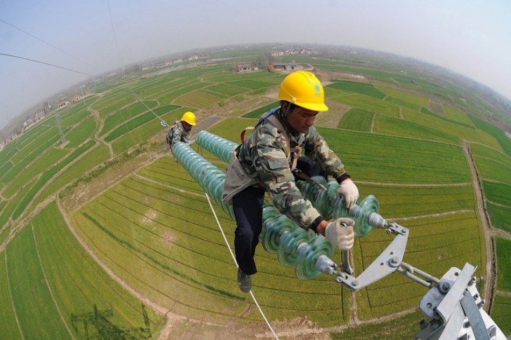 #4 Arbeiter an Hochspannungs-Masten in China