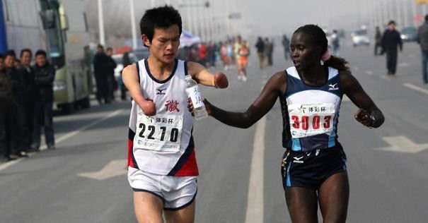 5. La maratoneta Jacqueline Kiplimo aiuta un partecipante disabile a finire la maratona a Taiwan.