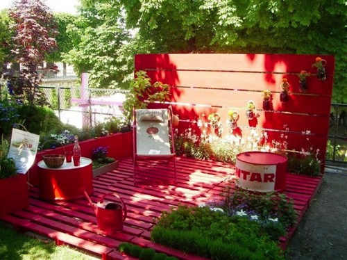Non è stupendo questo angolo nel giardino? La pedana è fatta interamente con pallet dipinti di rosso.