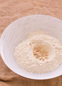 1. In una ciotola capiente mettete la farina setacciata con il lievito, e formate un buco al centro 