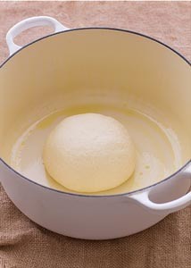 4. Placez la boule de pâte dans un récipient doté d'un couvercle, adapté au four. Laisser lever une heure et demie.