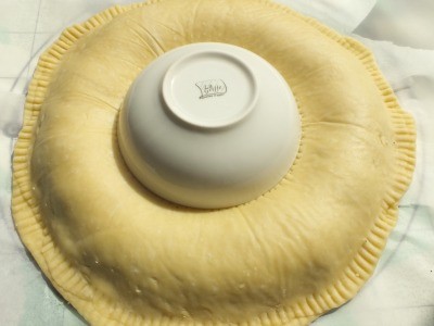 Au centre du cercle de pâte, mettre un petit bol et appuyez doucement. Piquer la pâte le long de la circonférence du bol avec une fourchette.