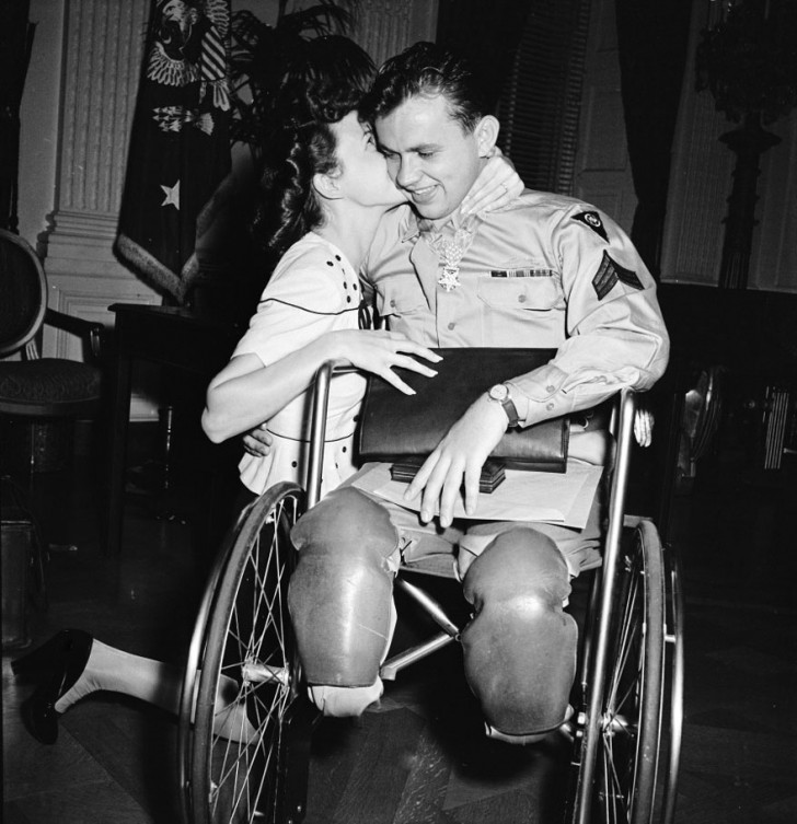 Jeune femme embrasse son petit ami de retour de la guerre en fauteuil roulant