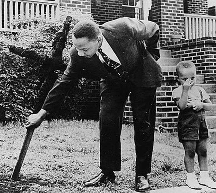 Martin Luther King rimuove, in compagnia del figlio, una croce bruciata che i membri del Ku Klux Klan gli hanno lasciato in giardino, 1960.