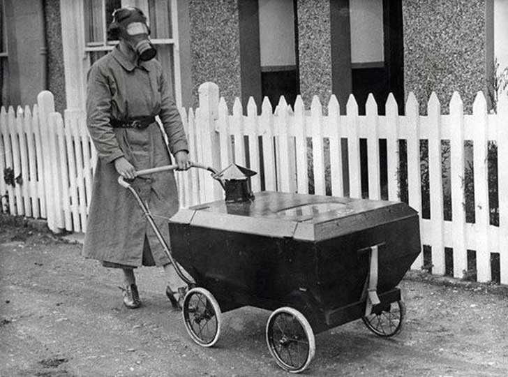 Une mère promène son fils dans une poussette à gaz, au cours de la Seconde Guerre mondiale.