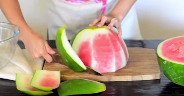 Plaats de watermeloen met de platte kant op een snijplank en verwijder de schil door van boven naar beneden de snijden