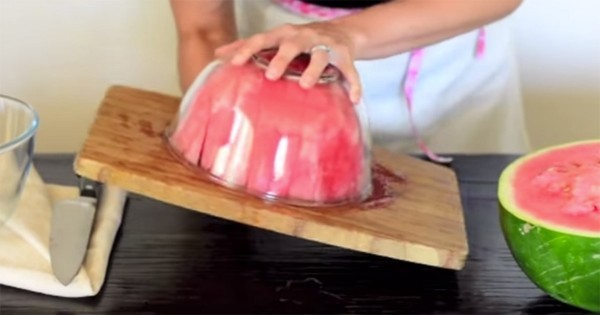 Draai de watermeloen en de kom met behulp van de snijplank om