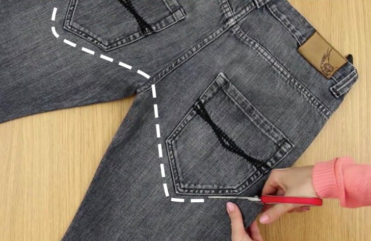 Lay the jeans on a table and start to cut off the legs up to the crotch while leaving intact the back pockets.