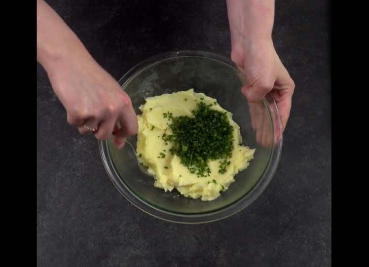 Mettete le patate bollite in una ciotola e schiacciatele con una forchetta. Aggiungete l'erba cipollina e amalgamate gli ingredienti.