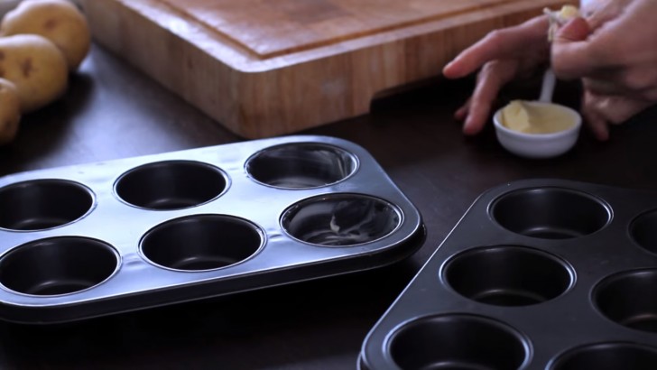 First of all, grease the muffin pans, spreading the butter into each cup.