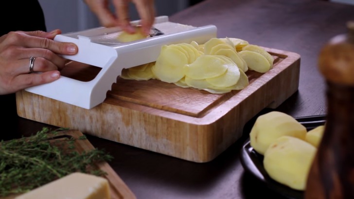 Snijd de aardappelen in dunne plakjes, bijvoorbeeld met behulp van een mandolinerasp. Pas op voor je vinger!
