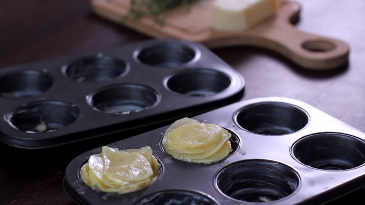 Maak stapeltjes van de aardappelplakjes en plaats deze torens in het muffinbakblik.