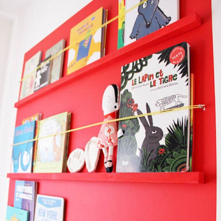 Om du inte vill ha en bokhylla kan du dekorera ditt barns sovrum med några enkla hyllor och bungee-rep.