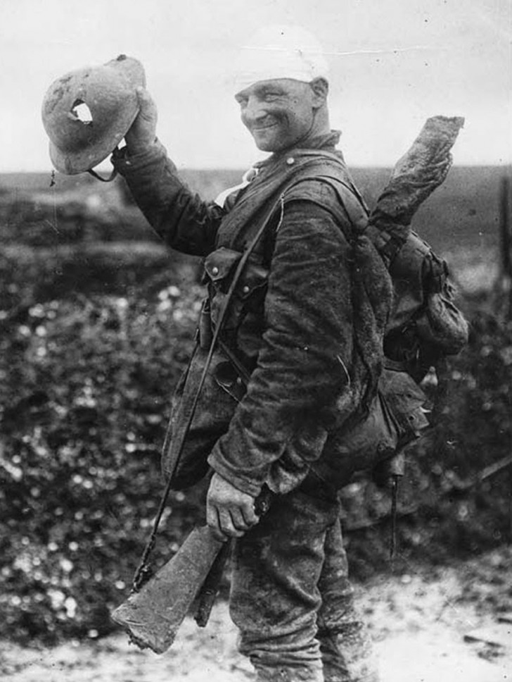 34. Soldat britannique montrant un trou de balle sur son casque-1918.