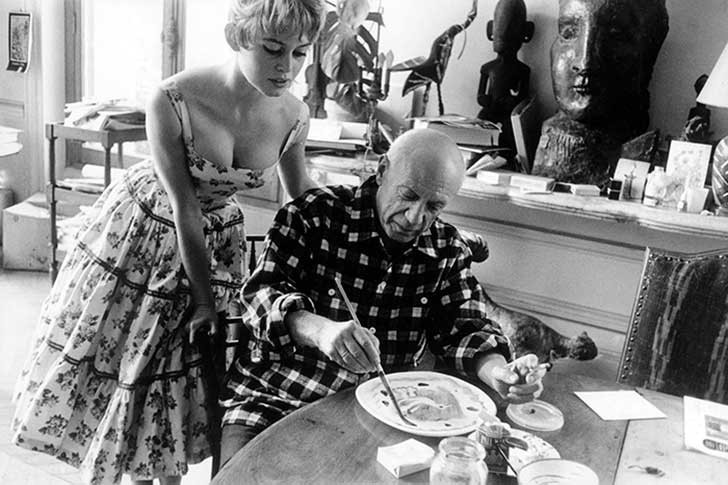 14. Brigitte Bardot osserva Pablo Picasso mentre dipinge in una pausa dal Festival di Cannes (Vallauris, 1956).