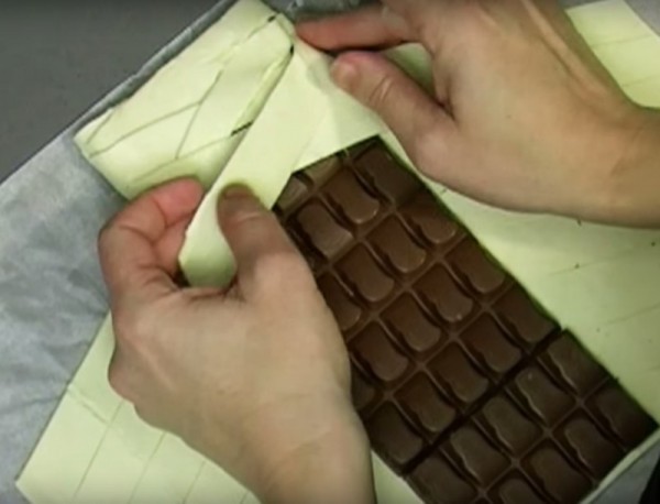 4. Prendete poi due strisce corrispondenti ai lati del cioccolato e sovrapponetele come a formare una treccia.