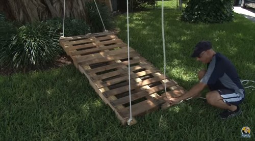 Drill holes in the four corners of the wooden pallets and attach strong ropes. At this point, you are ready to position the swing bed under a selected tree.