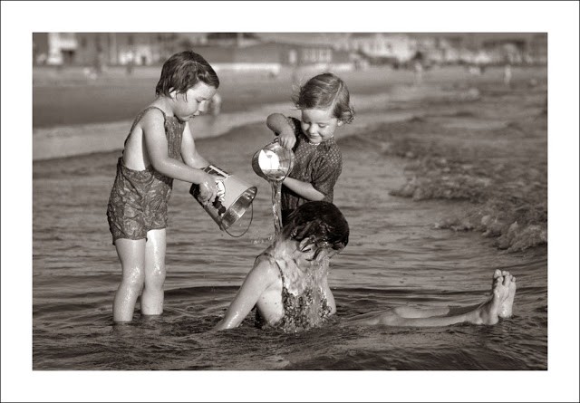 Trois enfants qui jouent au bord de la mer.