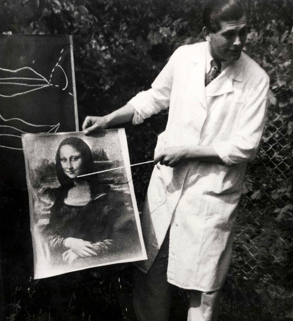 Un dottore indica ai pazienti l'importanza del sorriso, facendo riferimento al celebre dipinto della Monna Lisa.