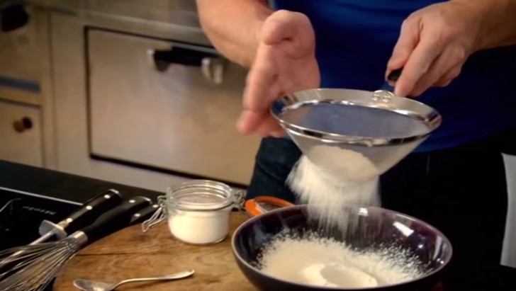 Iniziate a setacciare la farina con un cucchiaino di polvere lievitante, e aggiungete un pizzico di sale e di pepe.