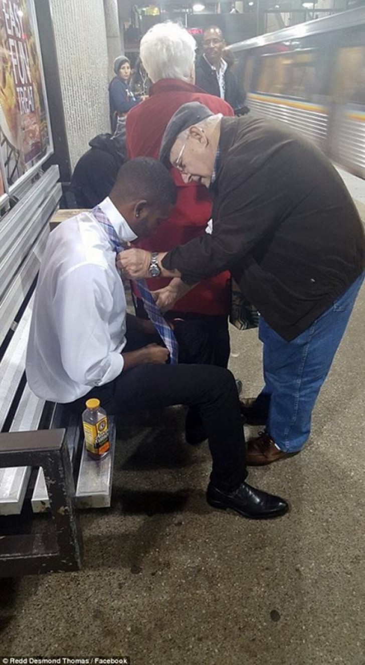 Un uomo aiuta un ragazzo ad allacciarsi correttamente la cravatta.