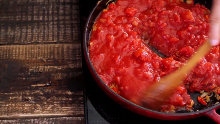 Gebt die Tomaten, das Tomatenmark und die Gewürze hinzu. Mischt alles gut und lasst es 15 Minuten auf kleiner Flamme köcheln.