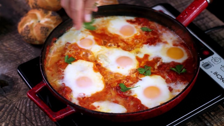 Cover with a lid and cook for 10 to 15 minutes. When the eggs are well-solidified, add parsley or coriander to garnish.