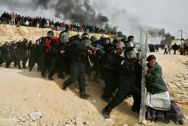 Una donna ebrea tenta da sola di respingere i soldati israeliani durante l'evacuazione di un insediamento in Cisgiordania (2007, foto premio Pulitzer).