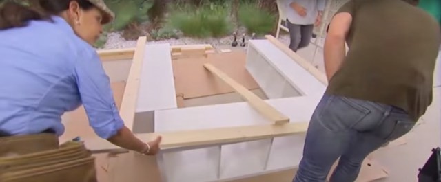 Cut three beams of plywood exactly the size of your mattress. Arrange the wooden beams along the sides of the three bookshelves.