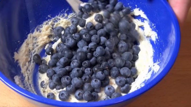 Aggiungete il composto di yogurt agli ingredienti secchi, poi unite i mirtilli e mescolate delicatamente senza schiacciarli.