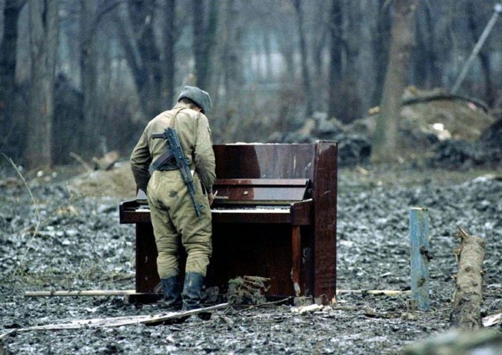 Een Russische soldaat komt dichterbij een bespeelt een verlaten piano in het hart van Tsjetsjenië in 1994