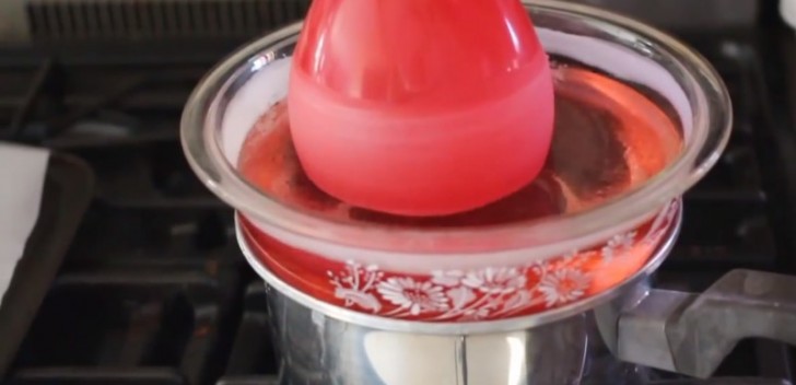Une fois dissoutes, verser la cire dans un pot plus grand et profond : prenez le ballon et plongez-le à plusieurs reprises dans le liquide pour créer une épaisseur de cire.