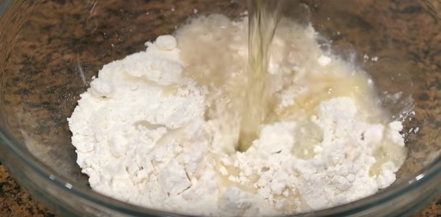 Add salt to the flour, and then pour in the hot water and oil.