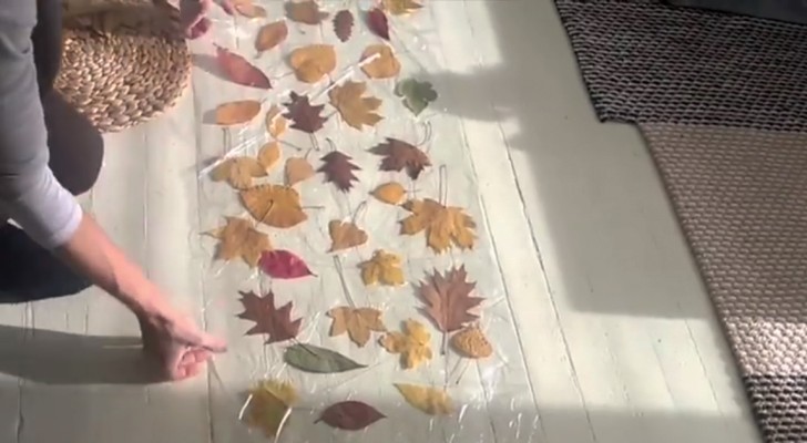 Elle insère des feuilles entre deux couches de plastique: le résultat donne magiquement un air d'automne à la maison
