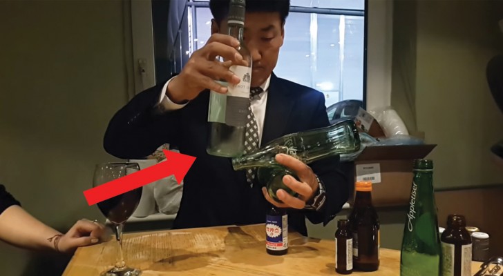 Er versucht 4 Flaschen aufeinander zu stellen: die Geschicktheit dieses Mannes ist erstaunlich
