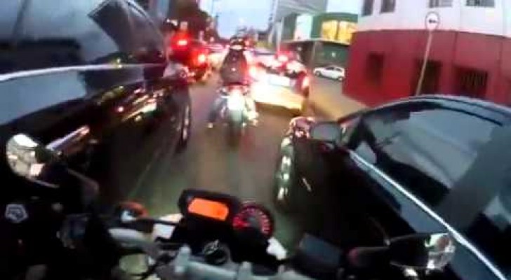 Un motard fonce en plein trafic. Discutable!