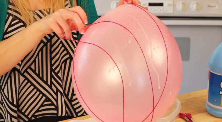 Hon sätter ett snöre runt en ballong: när hon är klar kan ni se vilka fina påskdekorationer hon har skapat