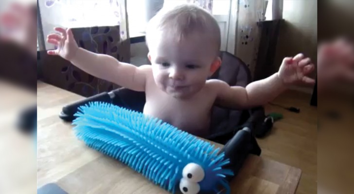  A baby touches a puffer caterpillar toy and is frightened in an adorable way