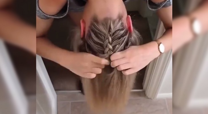 Elle baisse la tête et commence à faire une tresse à ses cheveux: en quelques gestes, elle obtient une coiffure au top